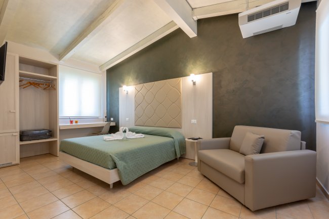 Camera moderna con letto matrimoniale e divano.