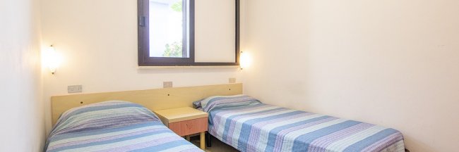 Camera con due letti singoli e luci da parete.