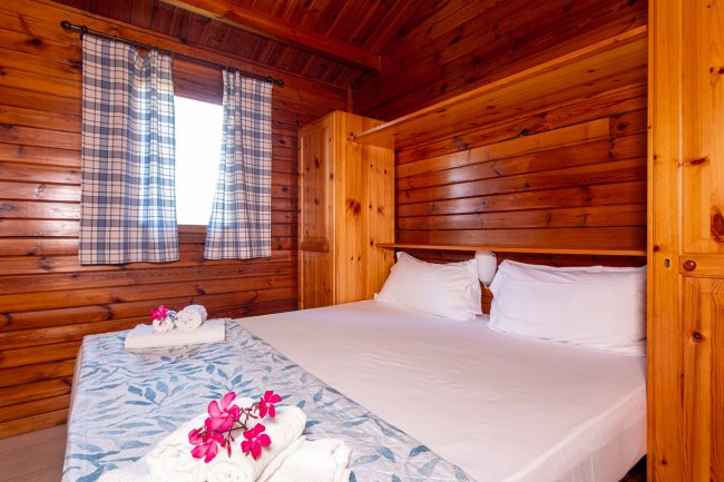 Camera con letto matrimoniale e arredi in legno.