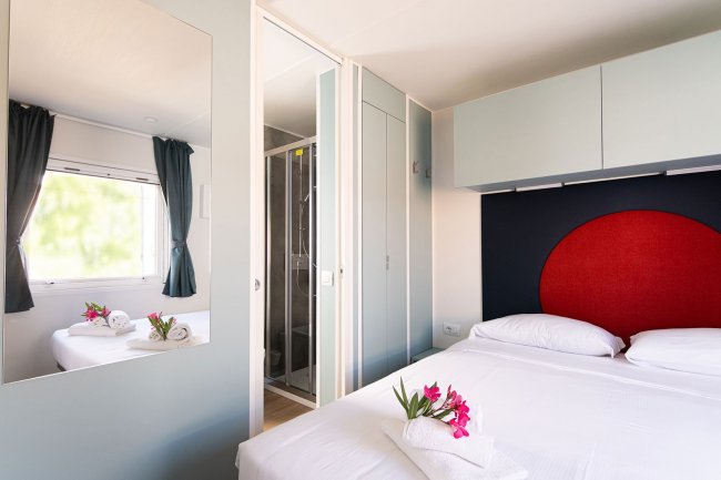 Camera elegante con letto matrimoniale e fiori.