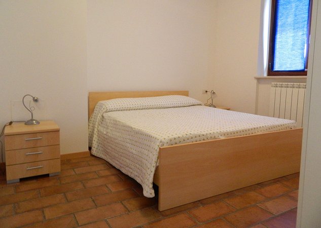 Camera con letto matrimoniale e comodino.