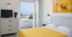 Camera moderna con vista mare e arredo giallo.