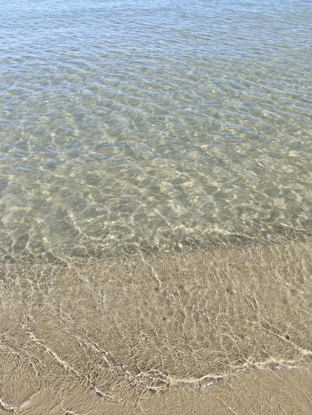 Acqua trasparente si infrange sulla sabbia.