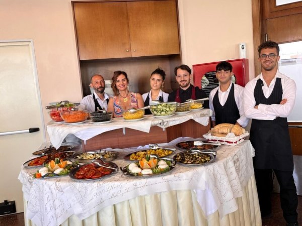 Gruppo in piedi dietro a un buffet di pietanze.