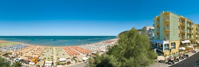Spiaggia affollata vista dall'alto, vicino a un hotel.