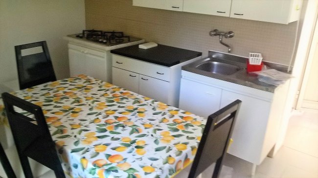 Cucina con tavolo a fantasia di limoni.