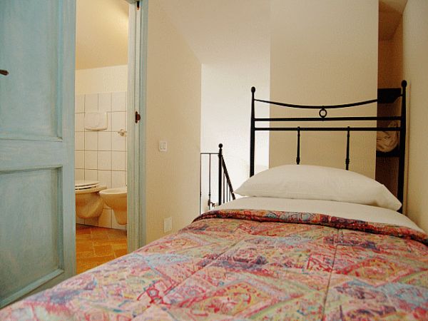Camera con letto singolo a fianco del bagno.