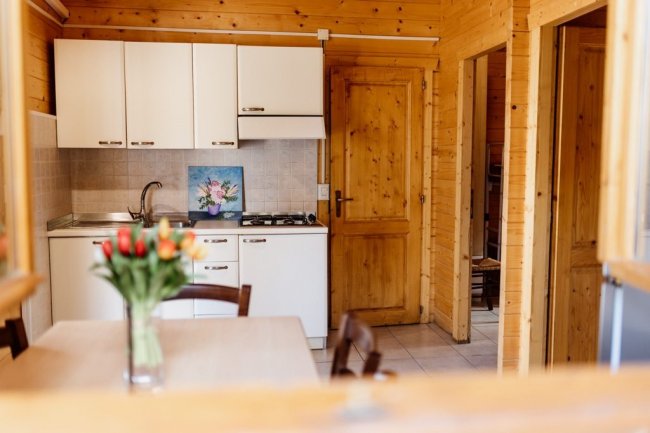 Cucina in legno con tavolo e fiori.